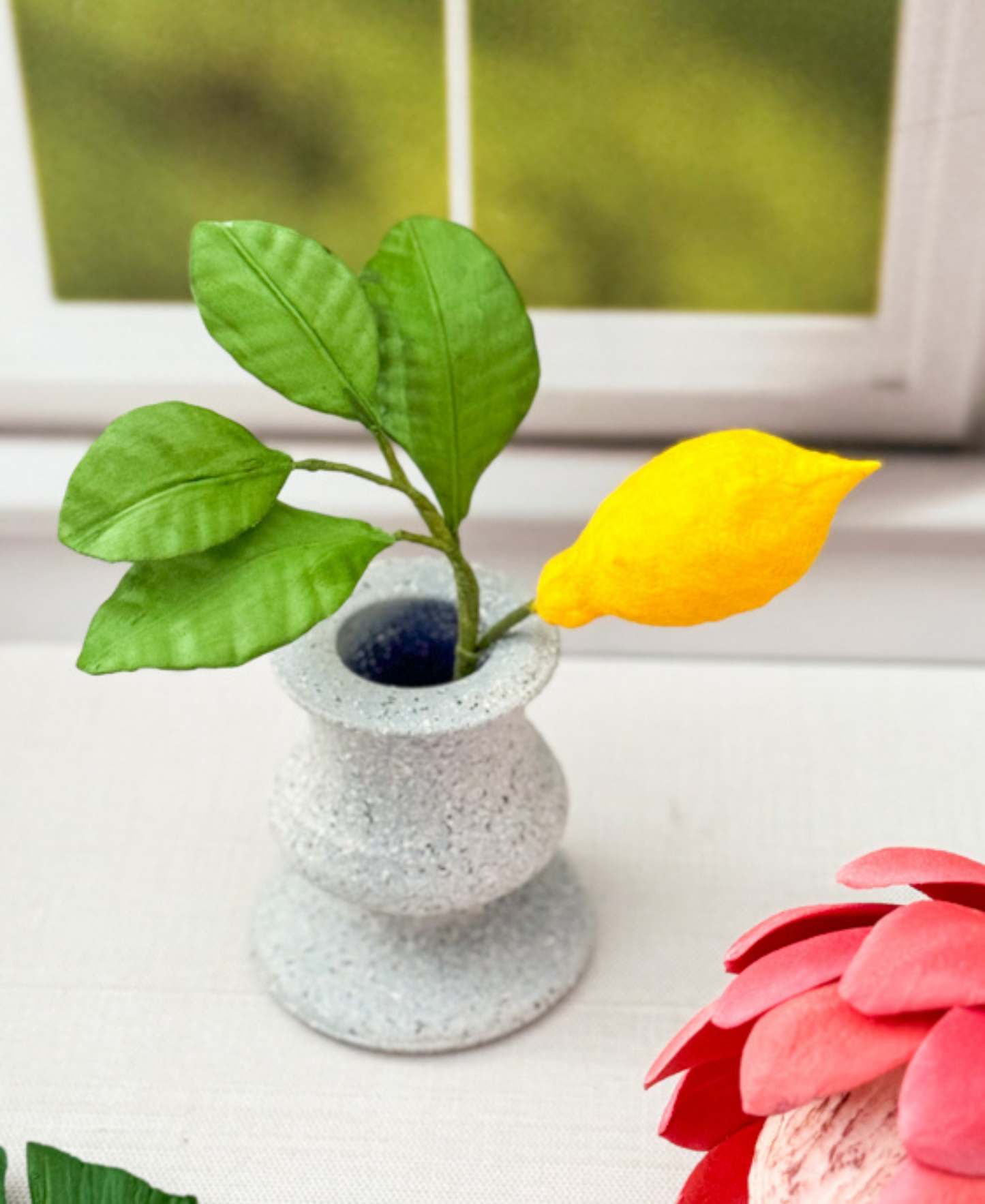 Gumpaste lemon with leaves in front of a window