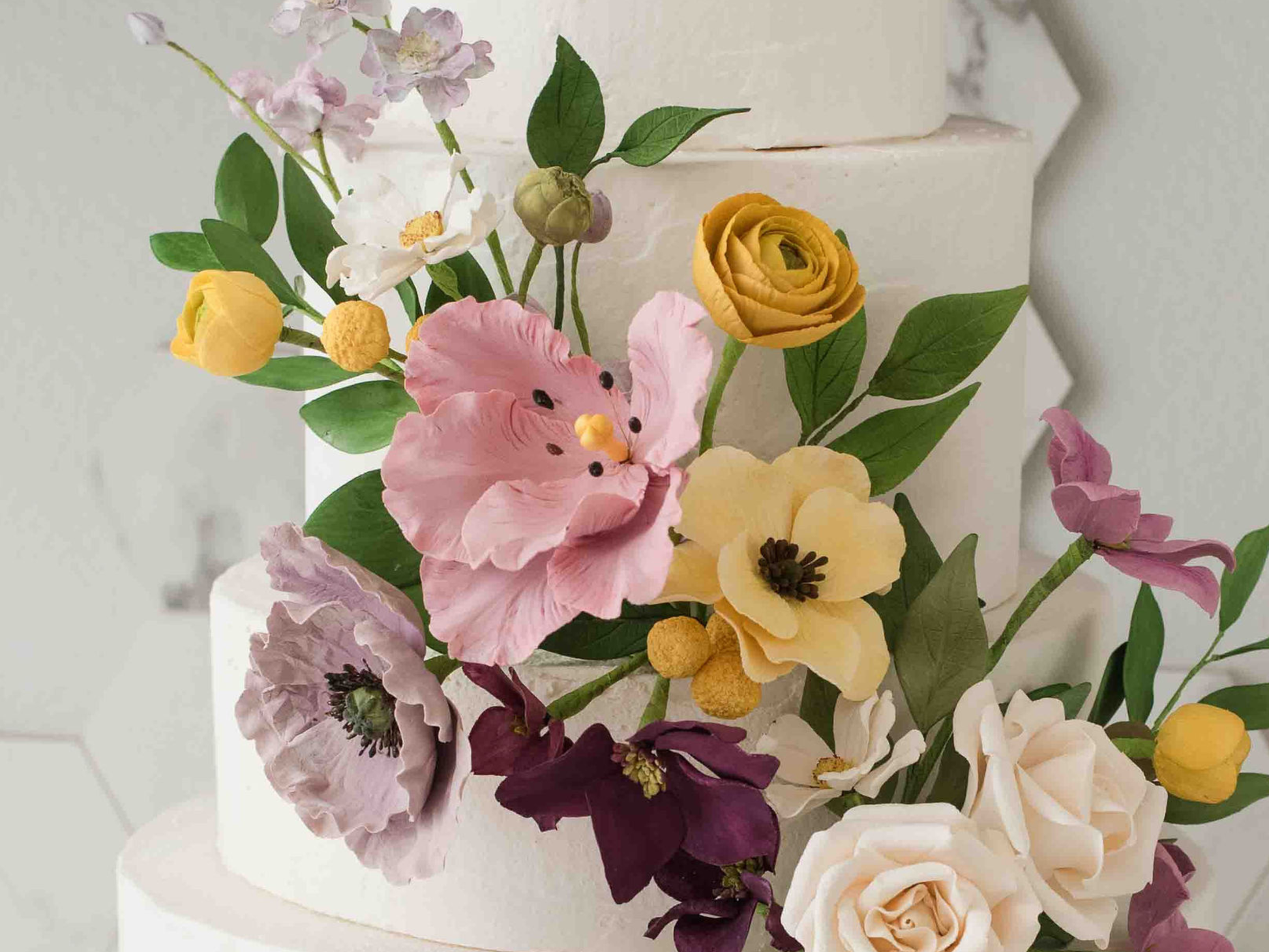 Decorative wedding cake with colorful flowers on a light background