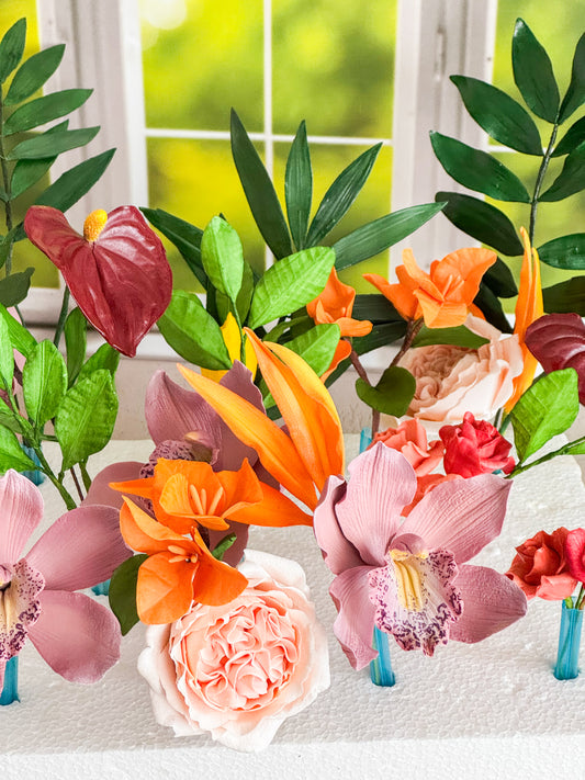 Colorful sugar flowers displayed on a table with a window in the background